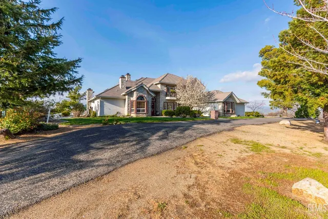 a patio with glass top table and chairs