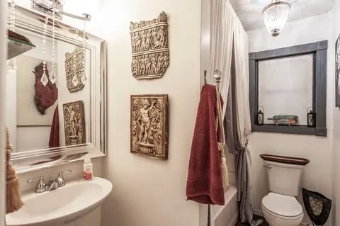 a bathroom with a toilet a sink and a mirror