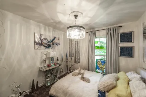 a bedroom with a bed and a chandelier