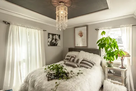 a bedroom with bed and a chandelier