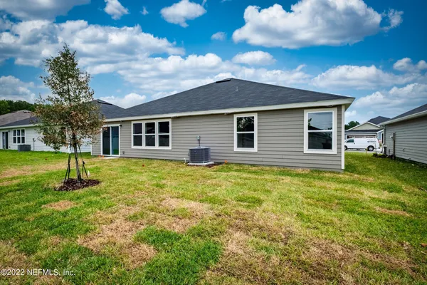 a view of a yard in front of a house with a large tree