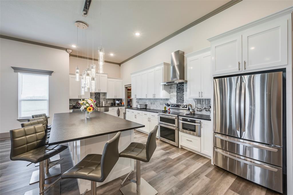 705 Old Agnes Road Weatherford, TX 76088 - Photo 3 of 32 a kitchen with kitchen island a stove a table and chairs in it