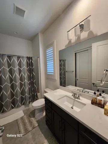 a bathroom with a double vanity sink toilet and a mirror