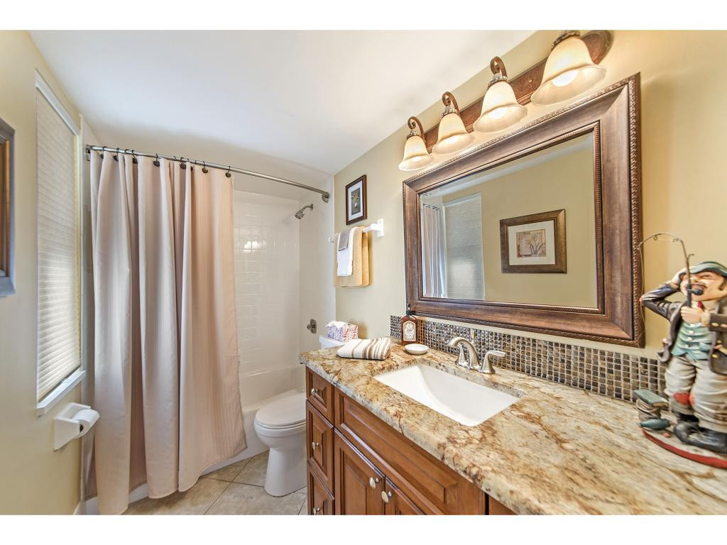 740 Teryl Road, Unit 2074 Naples, FL 34112 - Photo 13 of 18 a bathroom with a granite countertop sink a toilet and a mirror