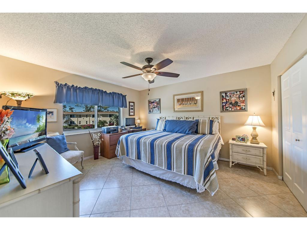 740 Teryl Road, Unit 2074 Naples, FL 34112 - Photo 5 of 18 a spacious bedroom with a bed a couch and a chandelier