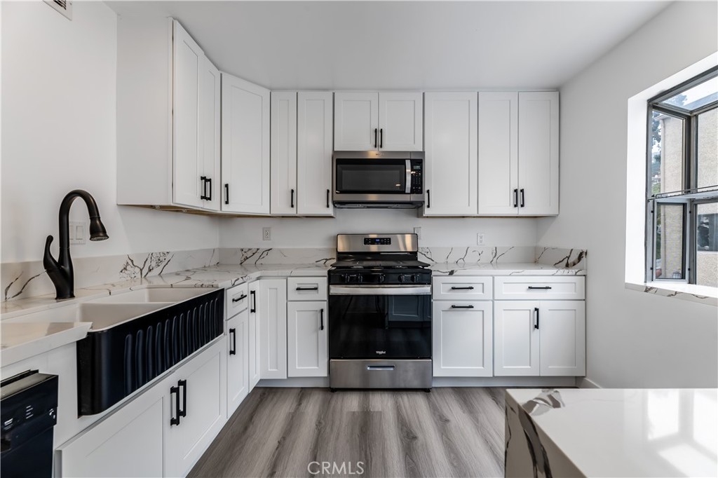 7953 Vía Latina Burbank, CA 91504 - Photo 6 of 30 a kitchen with granite countertop a sink stainless steel appliances and cabinets