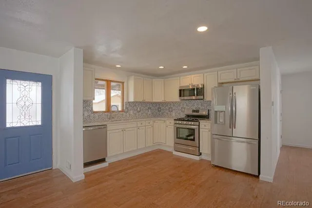 a kitchen with a refrigerator stove and sink
