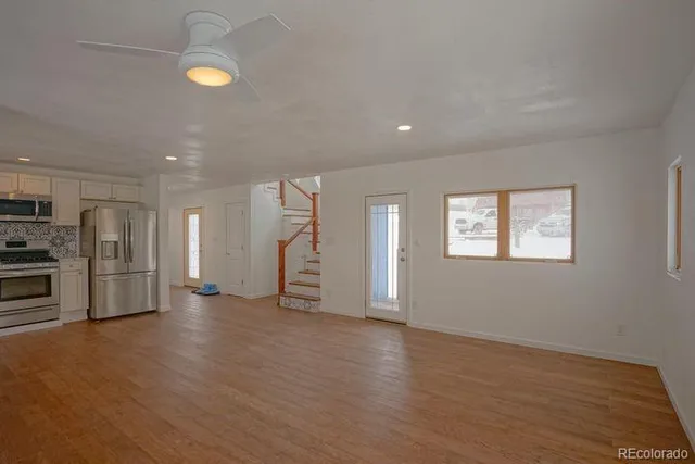 an empty room with wooden floor and window