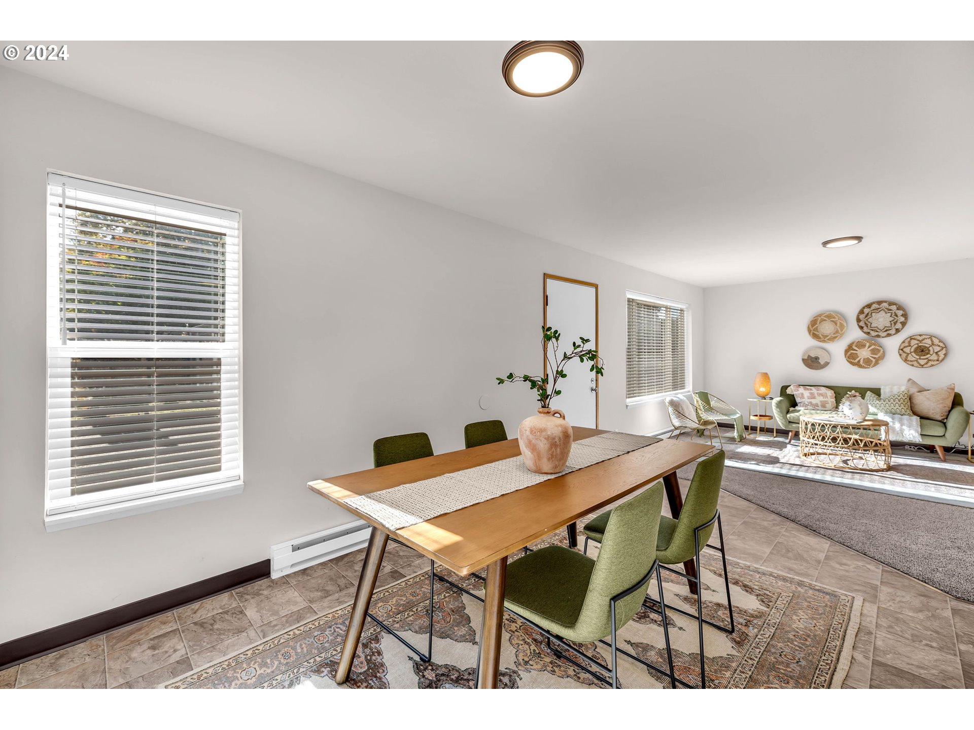 902 Pioneer Street, Unit 910 Ridgefield, WA 98642 - Photo 5 of 31 a view of a dining room and livingroom with furniture wooden floor and a rug