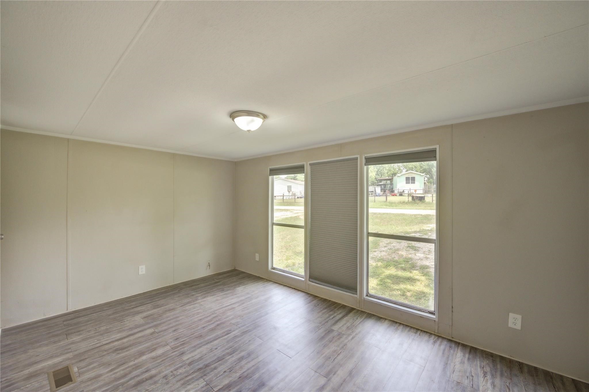 13265 Pecan Tree Drive Willis, TX 77318 - Photo 11 of 19 an empty room with wooden floor and windows