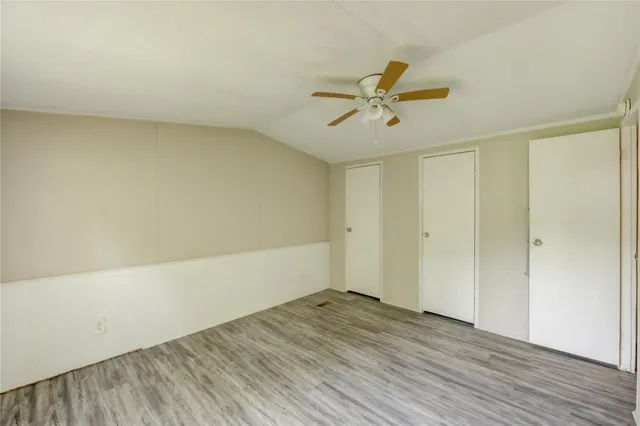 a view of a room with wooden floor and ceiling fan