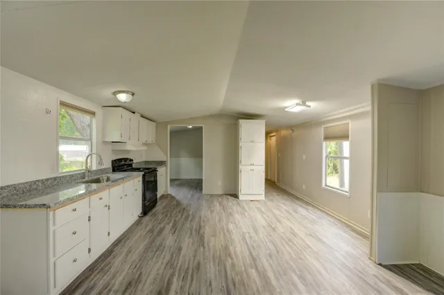 a large kitchen with a lot of counter space and wooden floor