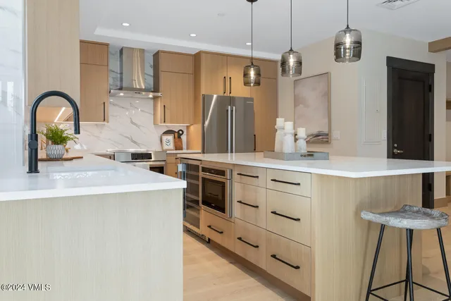 a kitchen with kitchen island a refrigerator and a sink