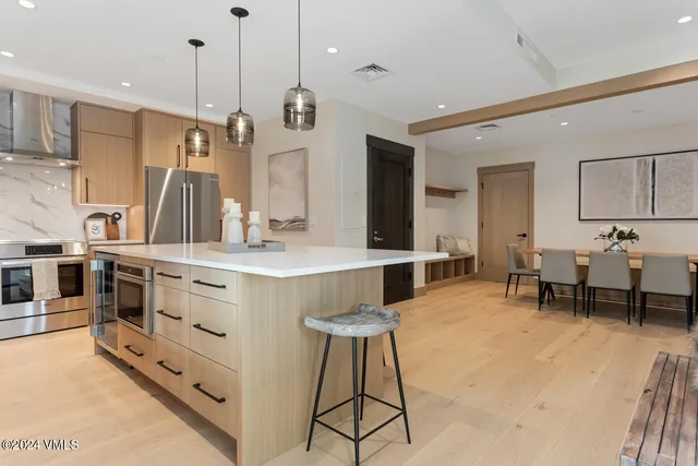 a large kitchen with kitchen island a large counter space a sink stainless steel appliances and cabinets