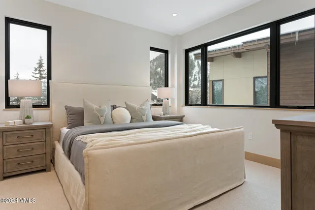 a bedroom with a bed and a mirror on dresser