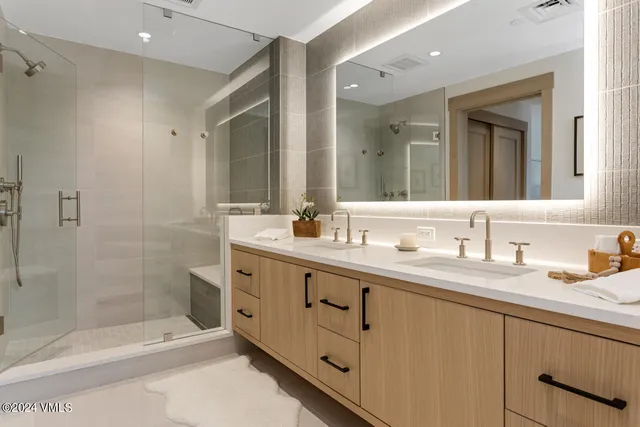 a bathroom with a shower tub double vanity sink and mirror