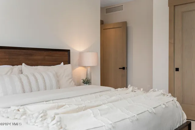 a bedroom with a bed and a mirror