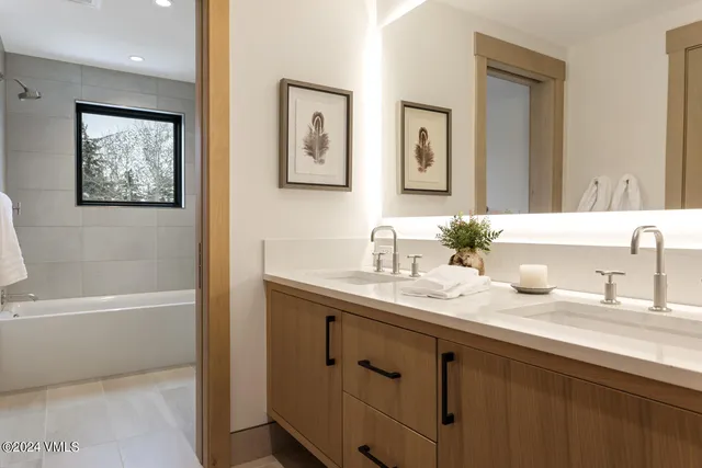a bathroom with a granite countertop sink mirror and a bath tub