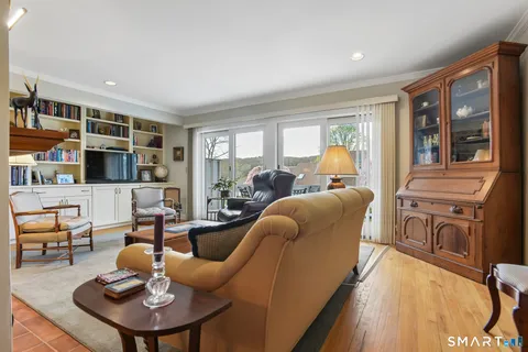 a living room with furniture a flat screen tv and a floor to ceiling window