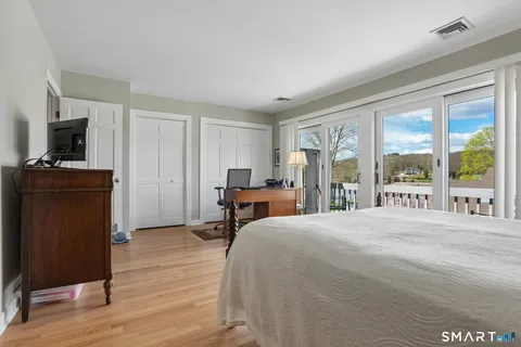 a bedroom with a bed and large windows