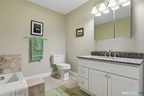 a bathroom with a toilet sink and mirror