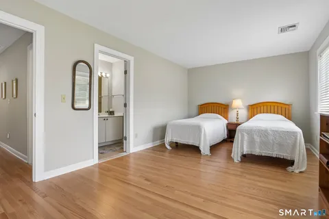 a bedroom with two beds and wooden floor