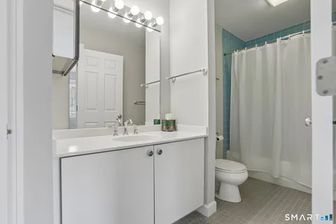 a bathroom with a toilet sink and mirror