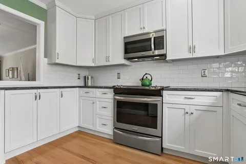 a kitchen with white cabinets stainless steel appliances and sink