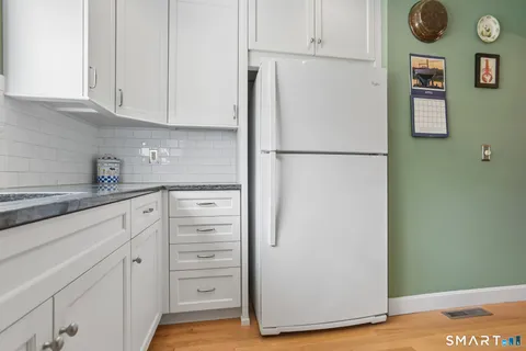 a white refrigerator freezer sitting inside of a kitchen