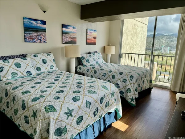 a bedroom with two beds next to a window