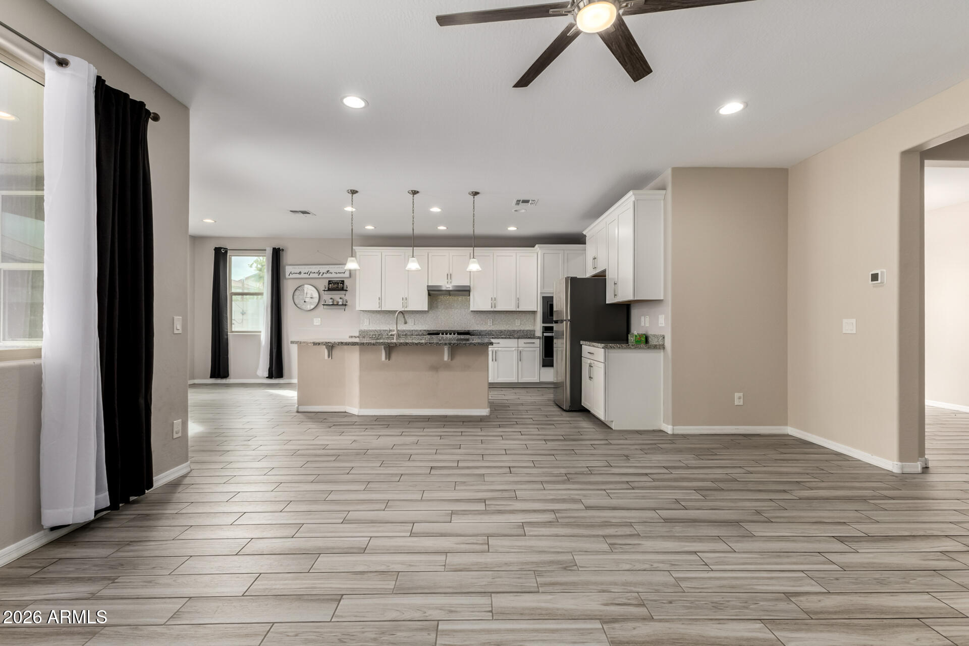 5347 West Lydia Lane Laveen, AZ 85339 - Photo 12 of 48 a large kitchen with stainless steel appliances kitchen island granite countertop a refrigerator and a stove top oven