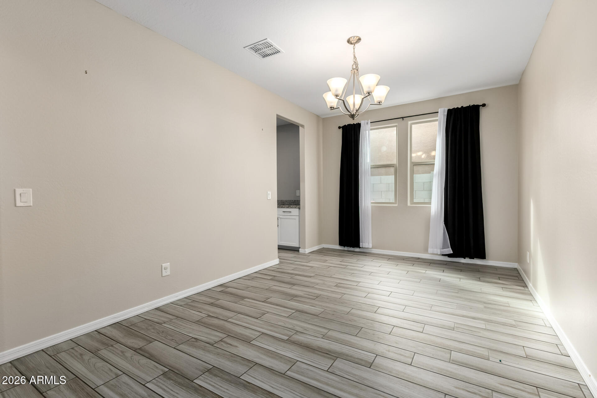 5347 West Lydia Lane Laveen, AZ 85339 - Photo 14 of 48 a view of an empty room with wooden floor and a window