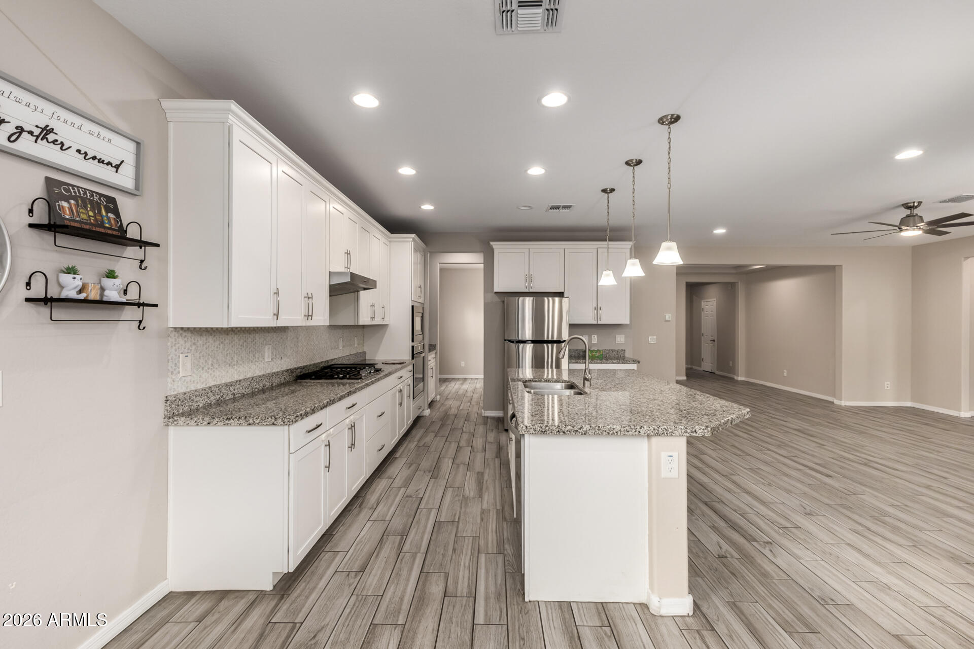 5347 West Lydia Lane Laveen, AZ 85339 - Photo 18 of 48 a large kitchen with stainless steel appliances kitchen island a large counter top and a wooden floors