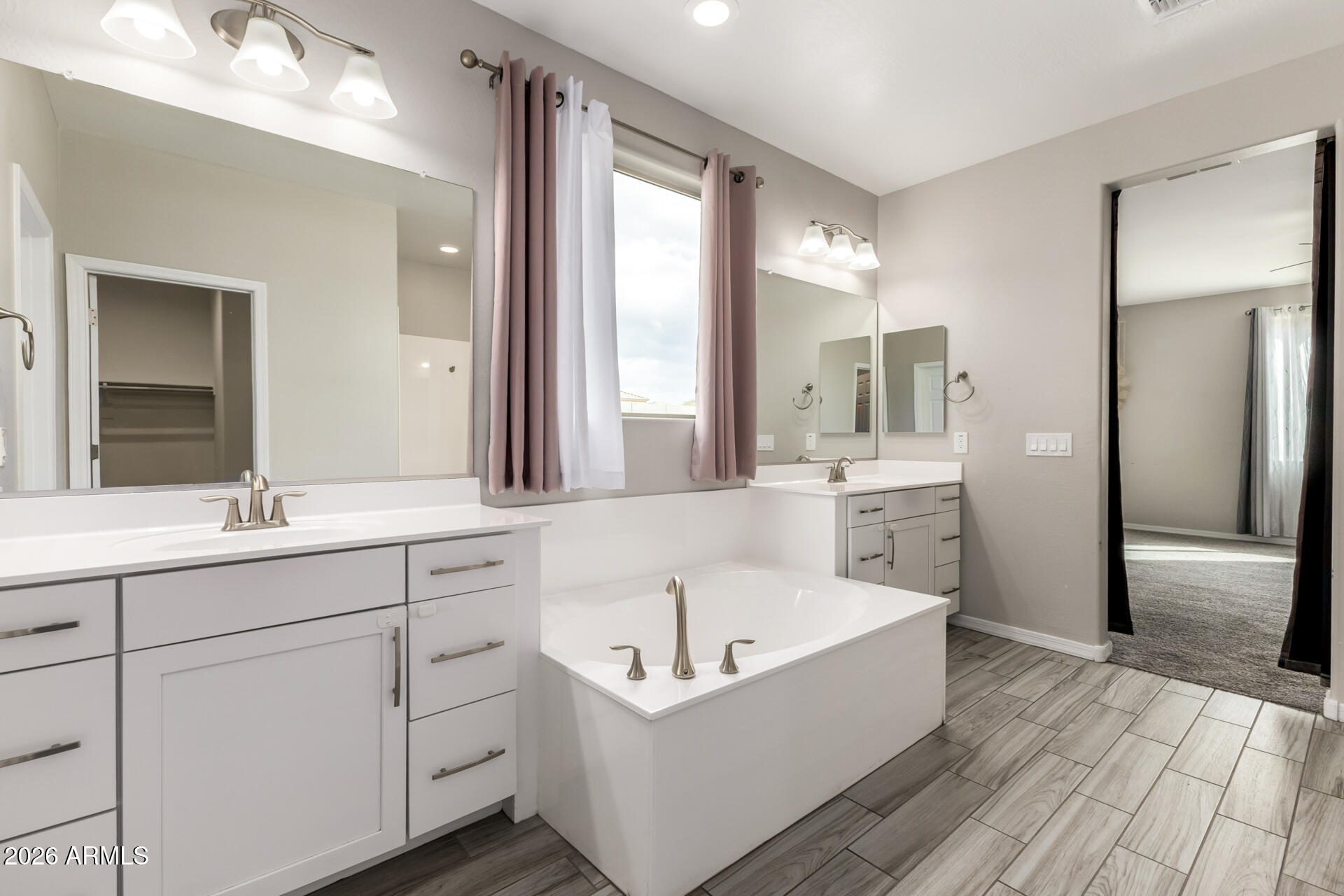 5347 West Lydia Lane Laveen, AZ 85339 - Photo 28 of 48 a bathroom with a bathtub a double vanity sink and a large mirror