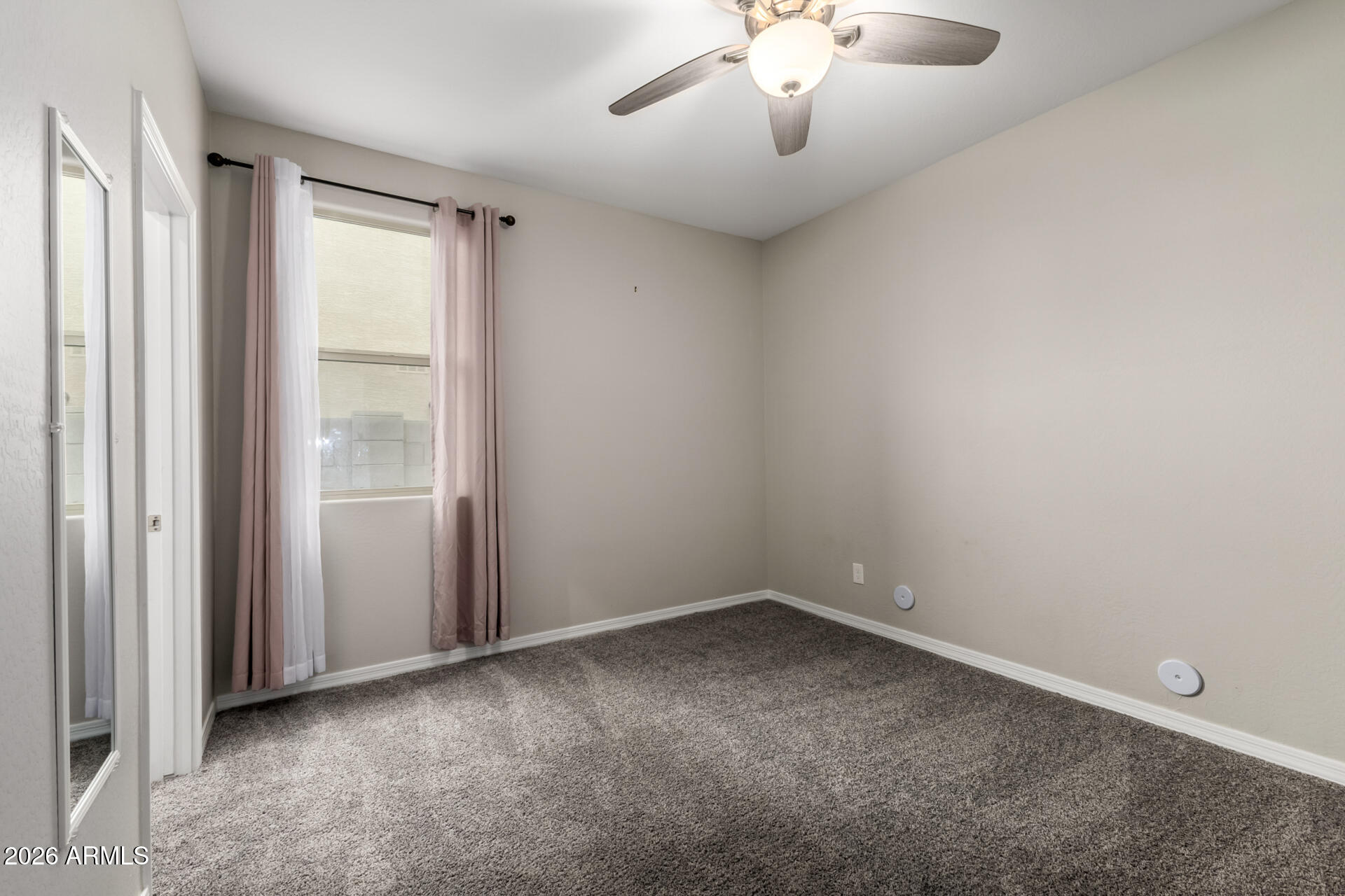 5347 West Lydia Lane Laveen, AZ 85339 - Photo 33 of 48 an empty room with a chandelier fan and windows
