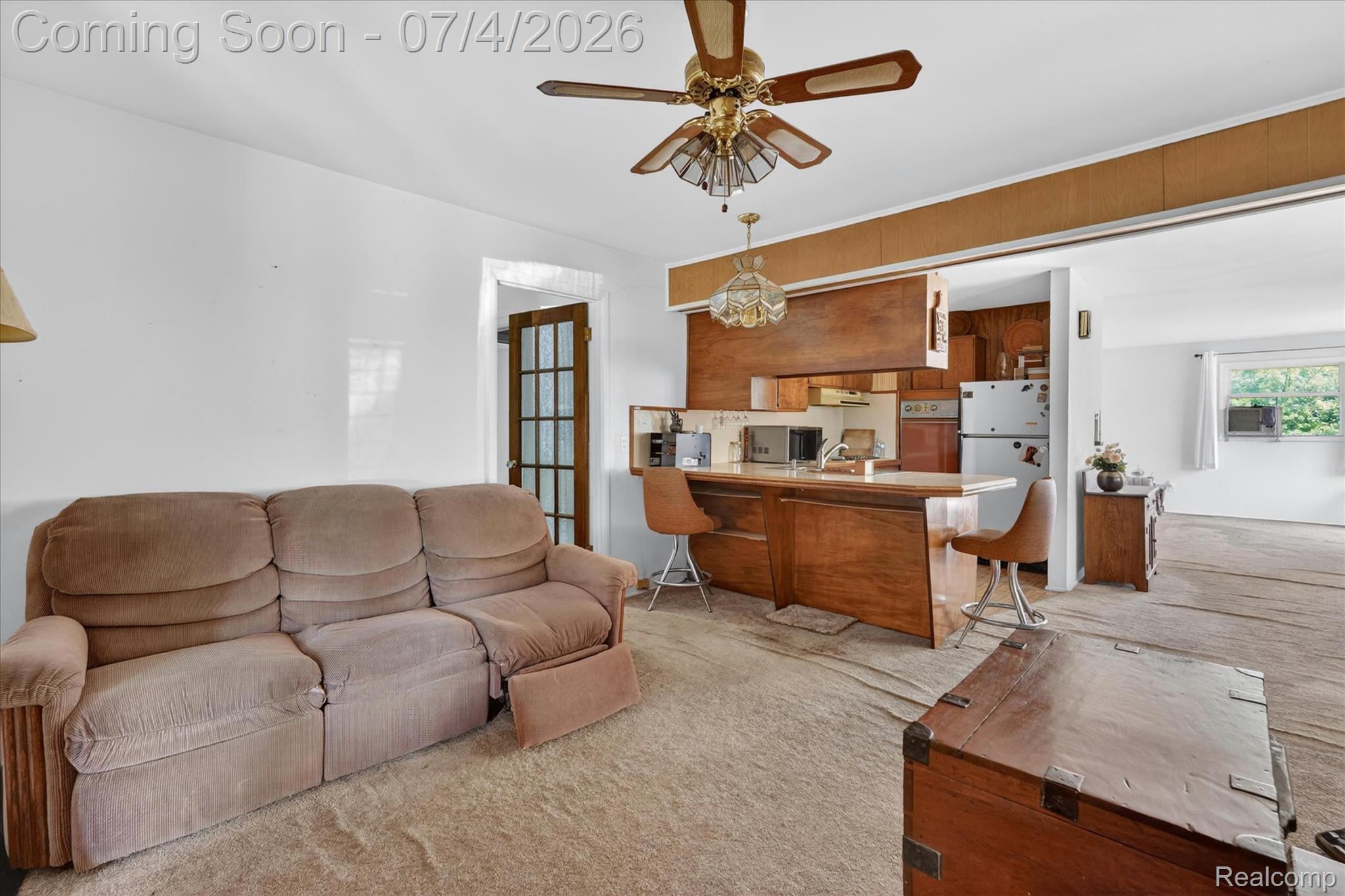 2091 North Irish Road Davison, MI 48423 - Photo 6 of 25 Open concept living area featuring wood-finish cabinetry, a breakfast bar, and a ceiling fan with integrated lighting
