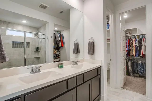a bathroom with a shower sink and mirror