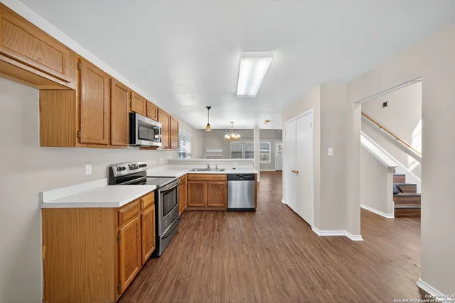 a kitchen with stainless steel appliances granite countertop wooden cabinets a stove top oven a sink and dishwasher