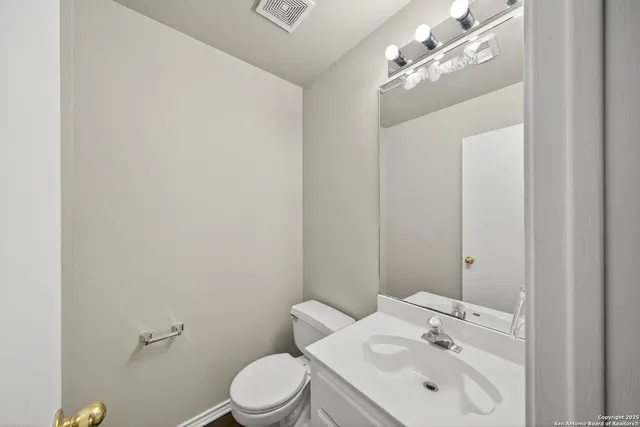 a bathroom with a toilet a sink and mirror