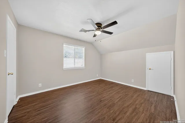 a view of a big room with wooden floor and windows
