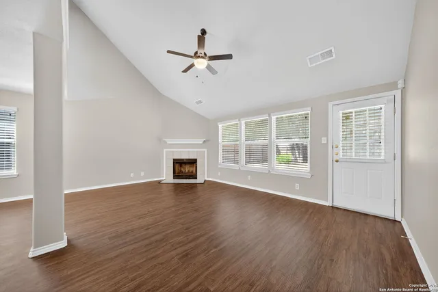 a view of empty room with wooden floor and fireplace