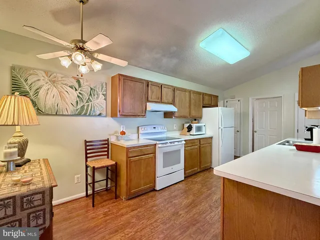 a kitchen with granite countertop a sink cabinets stainless steel appliances and a counter top space