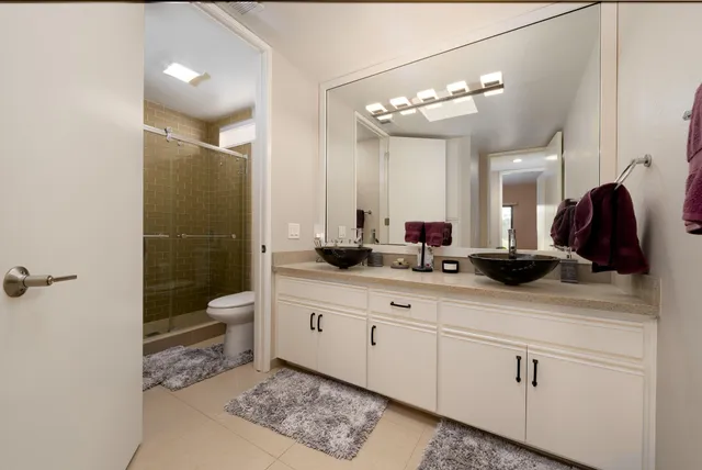 a bathroom with a double vanity sink toilet and shower