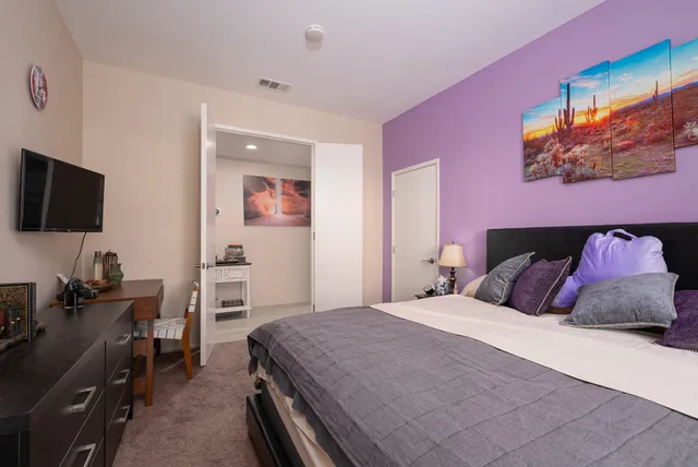 a bedroom with a bed and a flat screen tv