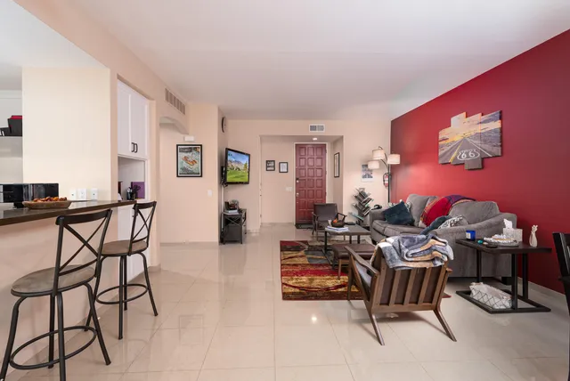 a living room with furniture and a flat screen tv with wooden floor