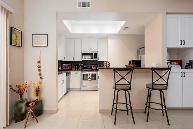 a kitchen with stainless steel appliances kitchen island granite countertop a stove a sink and a refrigerator