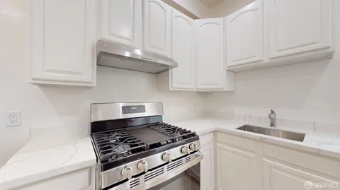 a kitchen with white cabinets and appliances