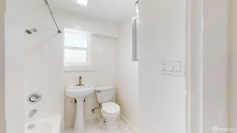 a bathroom with a sink toilet and window