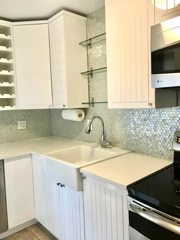 a kitchen with stainless steel appliances granite countertop a stove a sink a refrigerator and island