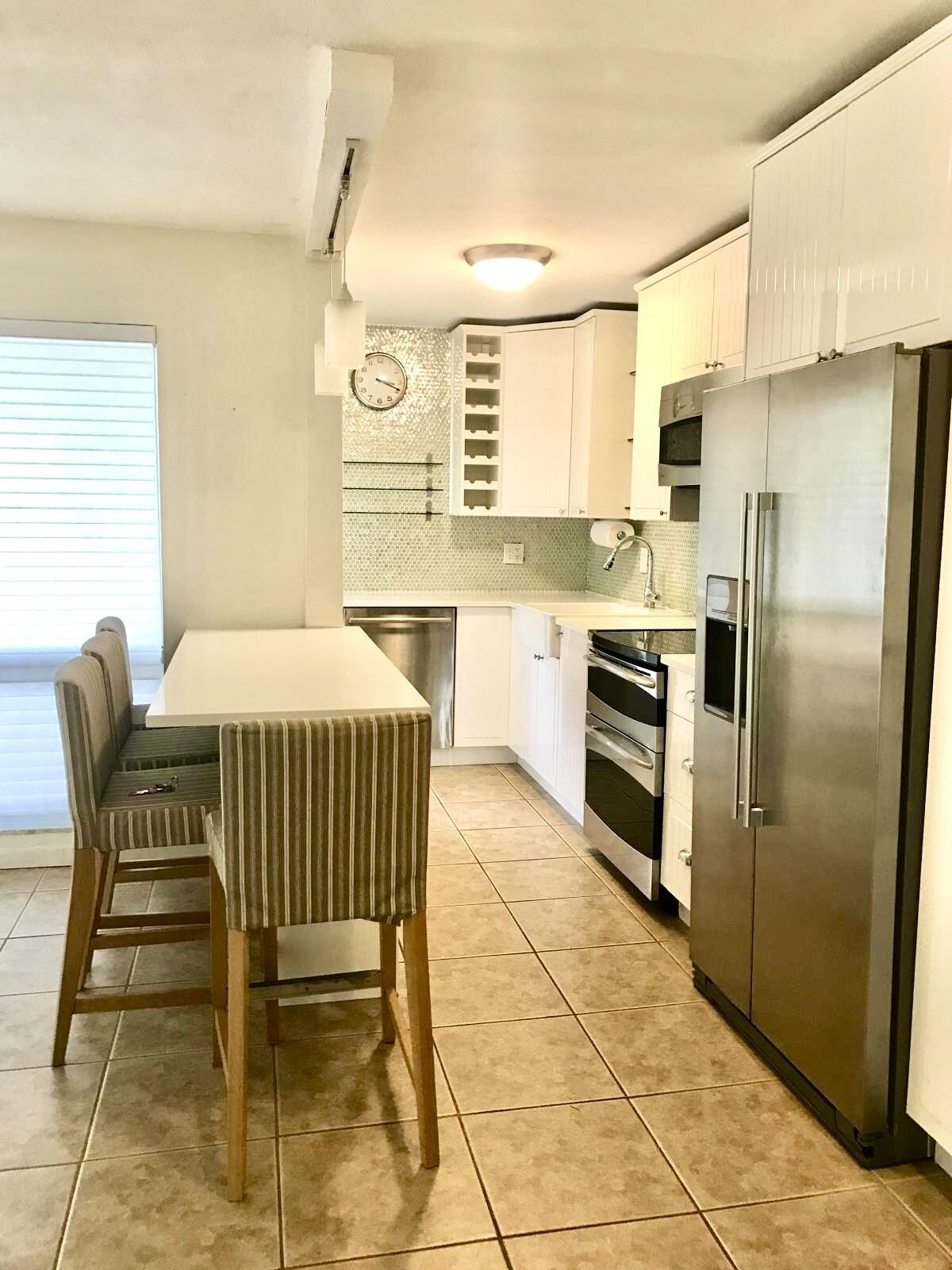 1439 South Ocean Boulevard, Unit 303 Lauderdale-by-the-Sea, FL 33062 - Photo 18 of 31 a kitchen with stainless steel appliances granite countertop a stove a sink a refrigerator and island